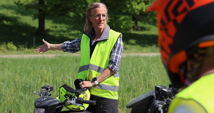 en lärare instruerar elev på fyrhjuling