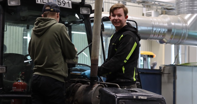 elev meckar en äldre traktor.