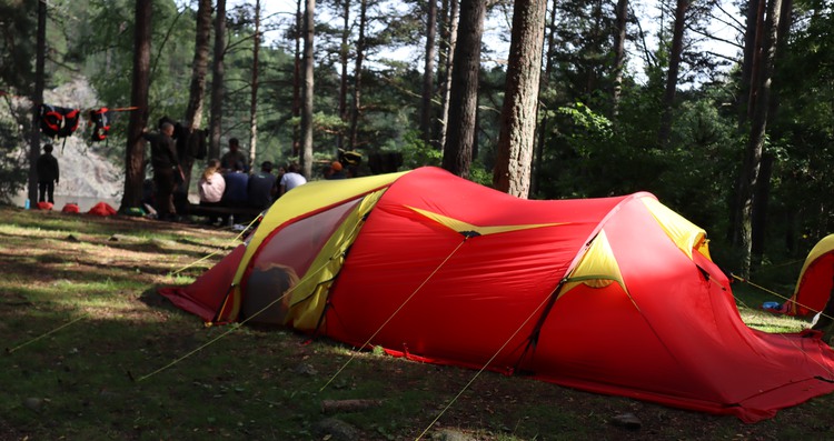 ett rött tält uppställt i naturen
